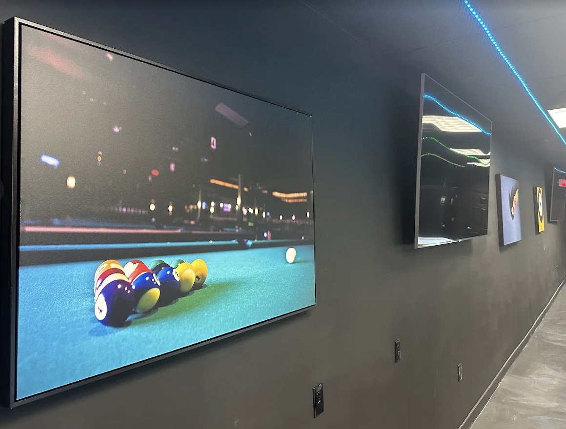 The gallery hallway with billiards artwork and blue light